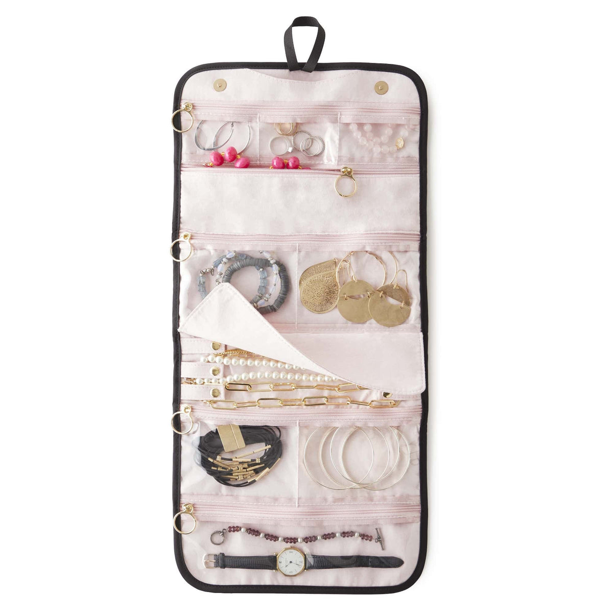 The KUSSHI - LARGE TRAVEL JEWELRY ORGANIZER by KUSSHI is a rolled-out jewelry organizer made with a premium nylon exterior. It features multiple transparent zippered compartments, offering compact travel storage for rings, earrings, bracelets, necklaces, and a watch. The organizer comes in pink with black edges and includes a black hanging loop at the top.