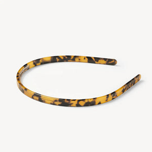 The MACHETE Ultralight Thin Headband in Tortoise features glossy Italian acetate in brown and yellow tones; it's lightweight, curved, fits all hair types, and is shown on a plain white background.