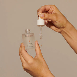 A frosted glass dropper bottle labeled “OMNILUX – PEPTIDE CONCENTRATE” features silver text and an orange starburst logo, containing 30 mL (1 fl oz) of skincare formula from OMNILUX enriched with powerful ingredients such as Argireline and Matrixyl.