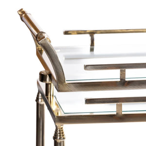 The SPIGA GOLD BAR CART by ZODAX features a vintage Italian-inspired design with elegant gold framing, mirrored glass shelves on both tiers, and smooth-rolling four-wheel mobility. Displayed against a white background, this piece is both stylish and functional.