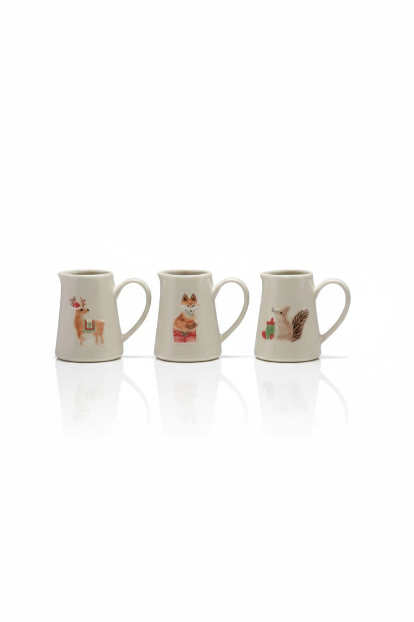 Three STONEWARE CREAMER WITH HOLIDAY ANIMAL pieces, each decorated with a hand-painted reindeer, fox, or squirrel.