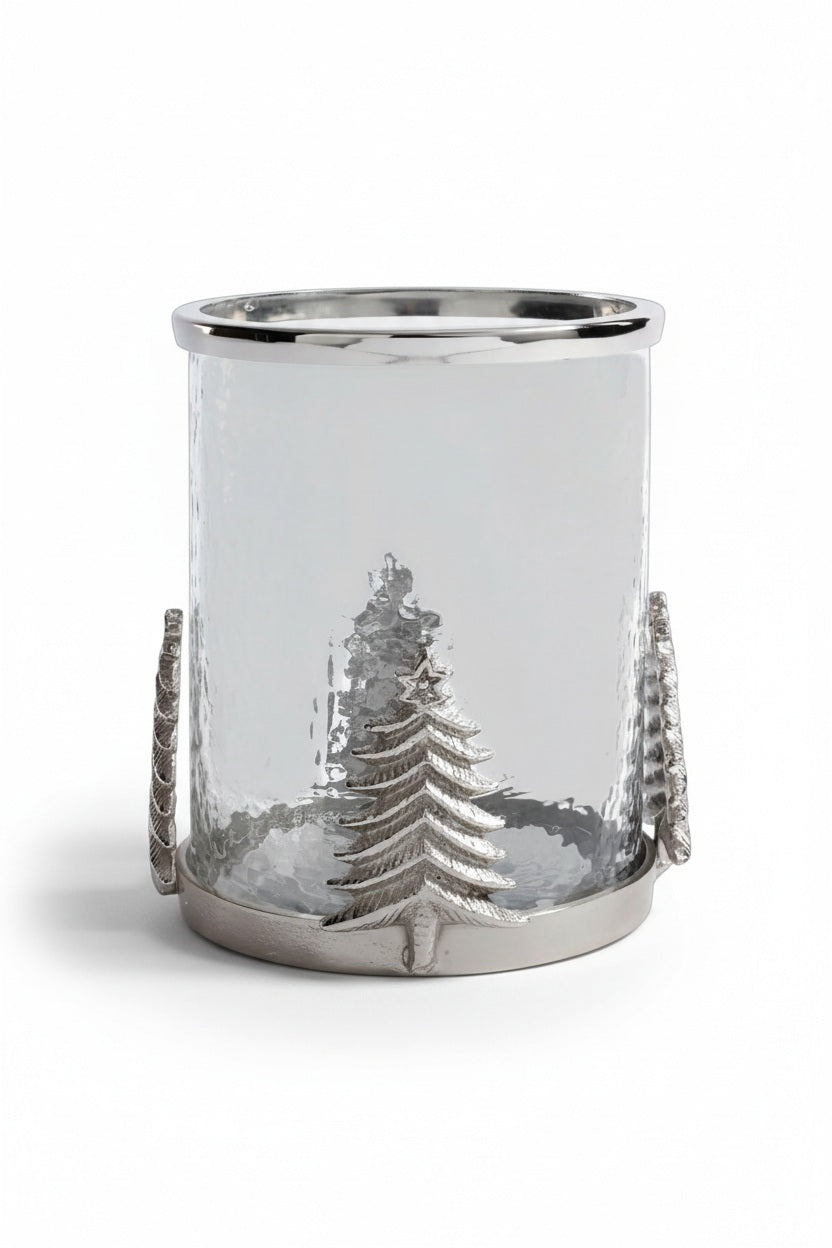 A ZODAX GLASS & ALLOY HURRICANE 8″ featuring a metallic base and silver Christmas tree accents, containing a lit white pillar candle.