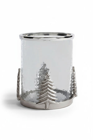 A ZODAX GLASS & ALLOY HURRICANE 8″ featuring a metallic base and silver Christmas tree accents, containing a lit white pillar candle.
