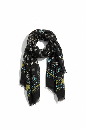 The STORIATIPIC - NELLY Wool Bandana Scarf with Embroidery in Black features a sophisticated paisley and floral design in shades of blue, green, and white. Delicately finished with small frayed edges and shown folded in a loose loop against a white background, this elegant accessory captures the essence of French designer flair, expertly crafted by STORIATIPIC to elevate any ensemble.
