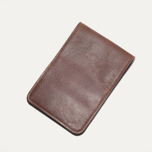 The WILL LEATHER GOODS GOLF YARDAGE BOOK IN COGNAC, by WILL LEATHER GOODS, features full-grain brown leather and a minimalist design—ideal for holding cards or a golf scorecard. It is shown closed on a plain white background.