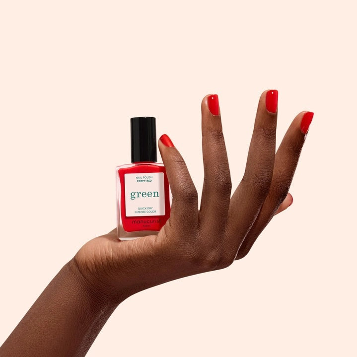 Twelve lipstick shades are presented with their names and color descriptions, spanning coral and brick reds to raspberries, cherries, and browns—each set against a backdrop of glossy swatches. These striking tones pair perfectly with the MANUCURIST - GREEN™ NAIL POLISH IN POPPY RED by MANUCURIST INC, a vibrant red nail polish crafted from bio-sourced ingredients for a coordinated and polished finish.
