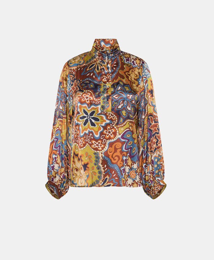The MOMONI - THIERRY BLOUSE IN PRINTED STRETCH SATIN is a long-sleeved, oversize silk blouse with a multicolored paisley and floral print, high pleated collar, and buttoned cuffs, shown on a plain white background.