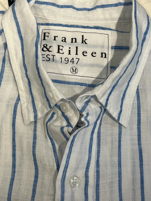 A man stands facing forward and smiling against a white background, wearing FRANK & EILEEN's FINBAR Men's Button Up Shirt in white with turquoise stripes (washed linen) and blue jeans.