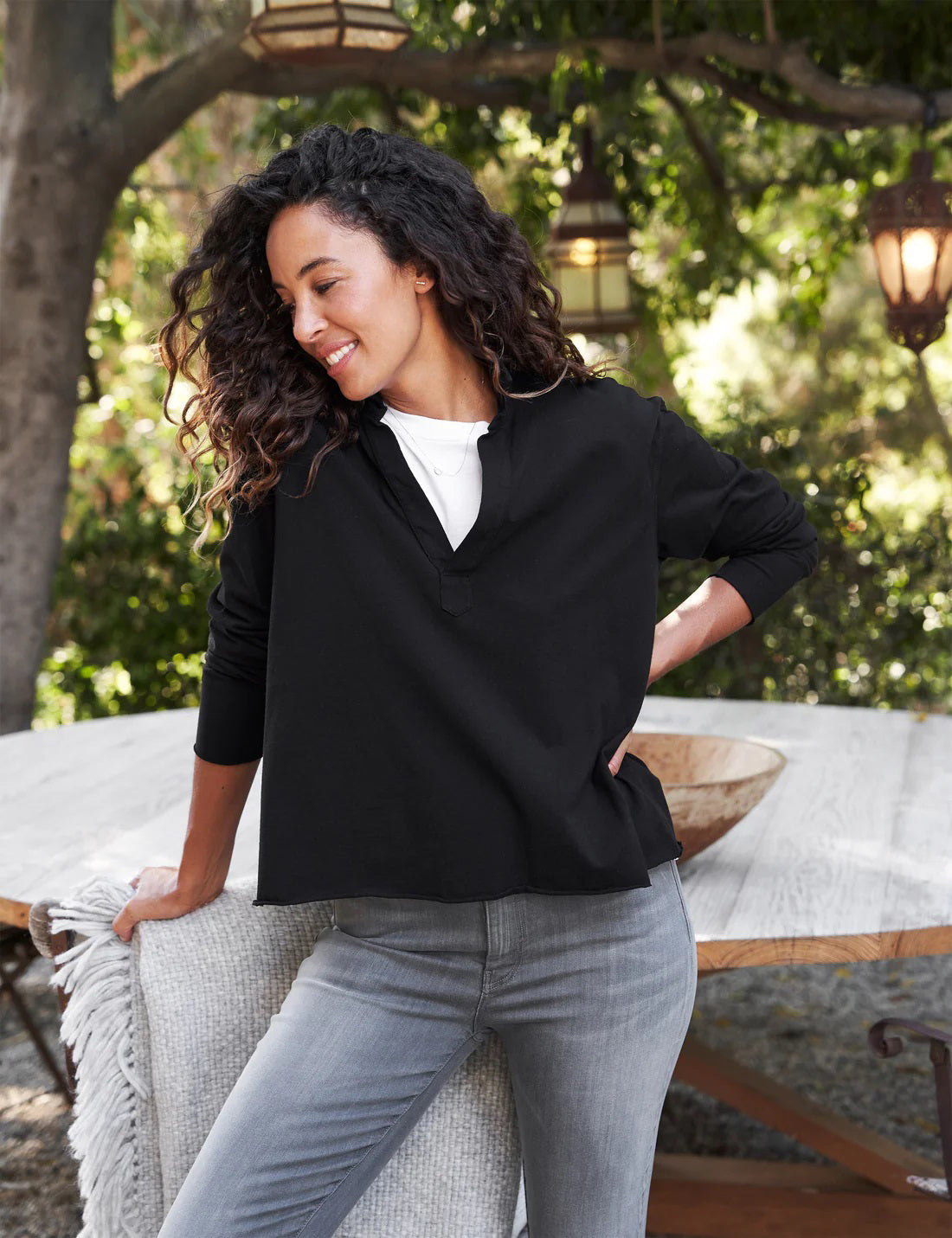 The FRANK &amp; EILEEN PATRICK POPOVER HENLEY in Heritage Jersey Black features a sporty V-neck with a collar and raw-cut hem, set against a light, textured background.