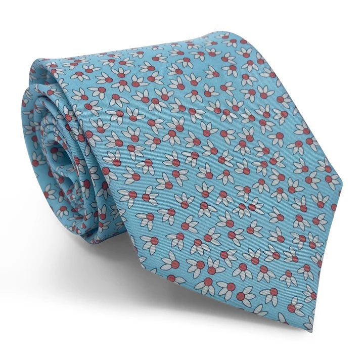 The BIRD DOG BAY PETER-BLAIR Spike Printed Silk Tie in Aqua features a handmade design with a repeating pattern of small white flowers with red centers and gray leaves, shown with its pointed end facing downward.