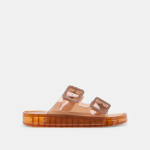 The DOLCE VITA - JULIO WHISKEY SANDAL by DOLCE VITA is a translucent orange jelly sandal with two wide straps, bold matching buckles, and a flat chunky sole for a simple, modern look.