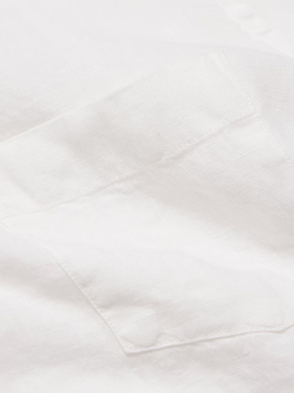 The HARTFORD - PAUL LINEN SHIRT IN WHITE by HARTFORD is a long-sleeved, button-up men's shirt crafted from premium European Flax linen, featuring a collar and single chest pocket, shown flat on a plain light grey background.