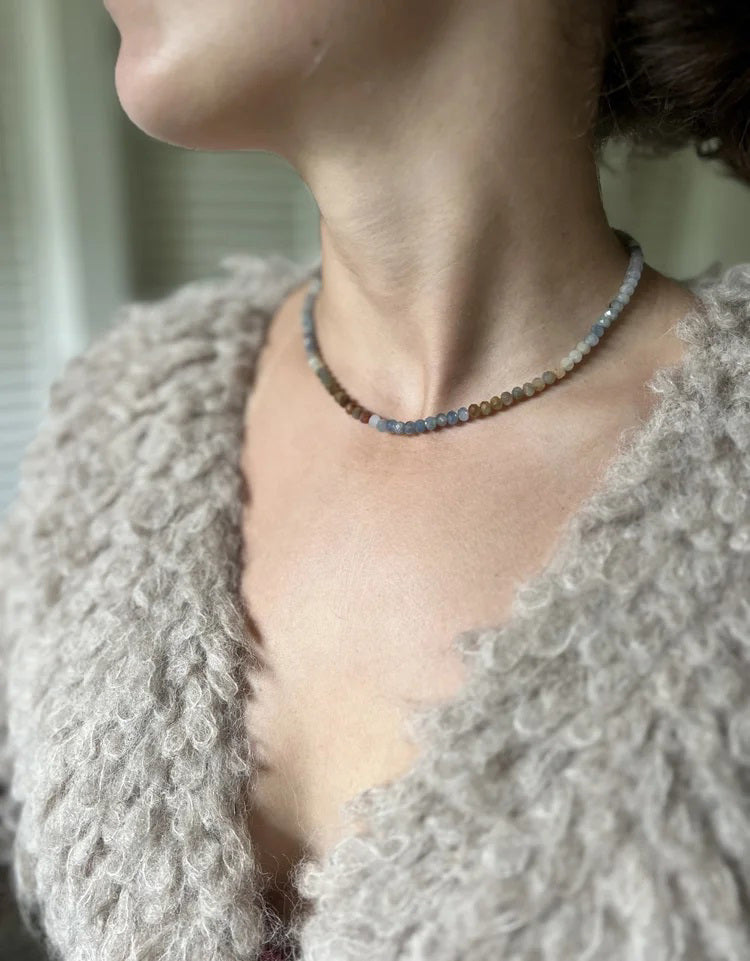 The ANN LIGHTFOOT Multi Color Sapphire Ras Du Cou Necklace features small, round sapphire beads in a smooth gradient from pale blue to yellow, orange, and light brown, finished with a sterling silver clasp.