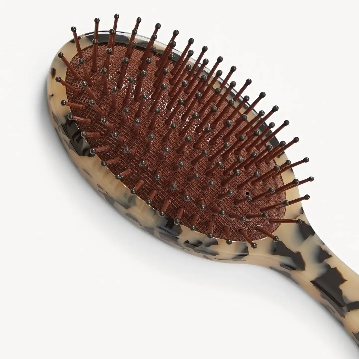 The MACHETE Everyday Detangling Hair Brush in Blonde Tortoise features a tortoiseshell-patterned Italian acetate handle and black-tipped nylon bristles set in a maroon cushion, shown against a plain white background.