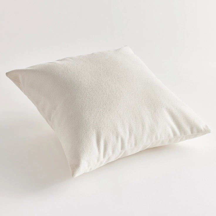 Against a plain white background, the NAPA HOME AND GARDEN - COOPER SQUARE INDOOR-OUTDOOR PILLOW 20&quot;, with its soft and fluffy Jacquard texture, appears smooth and slightly plump, ideal for resting or sleeping in any weather-resistant setting.