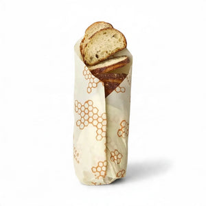 A baguette wrapped in the BEES WRAP- BEESWAX REUSABLE BREAD WRAP HONEYCOMB by BEES WRAP, filled with golden French fries and topped with two slices of bread and melted cheese, set against a white background.