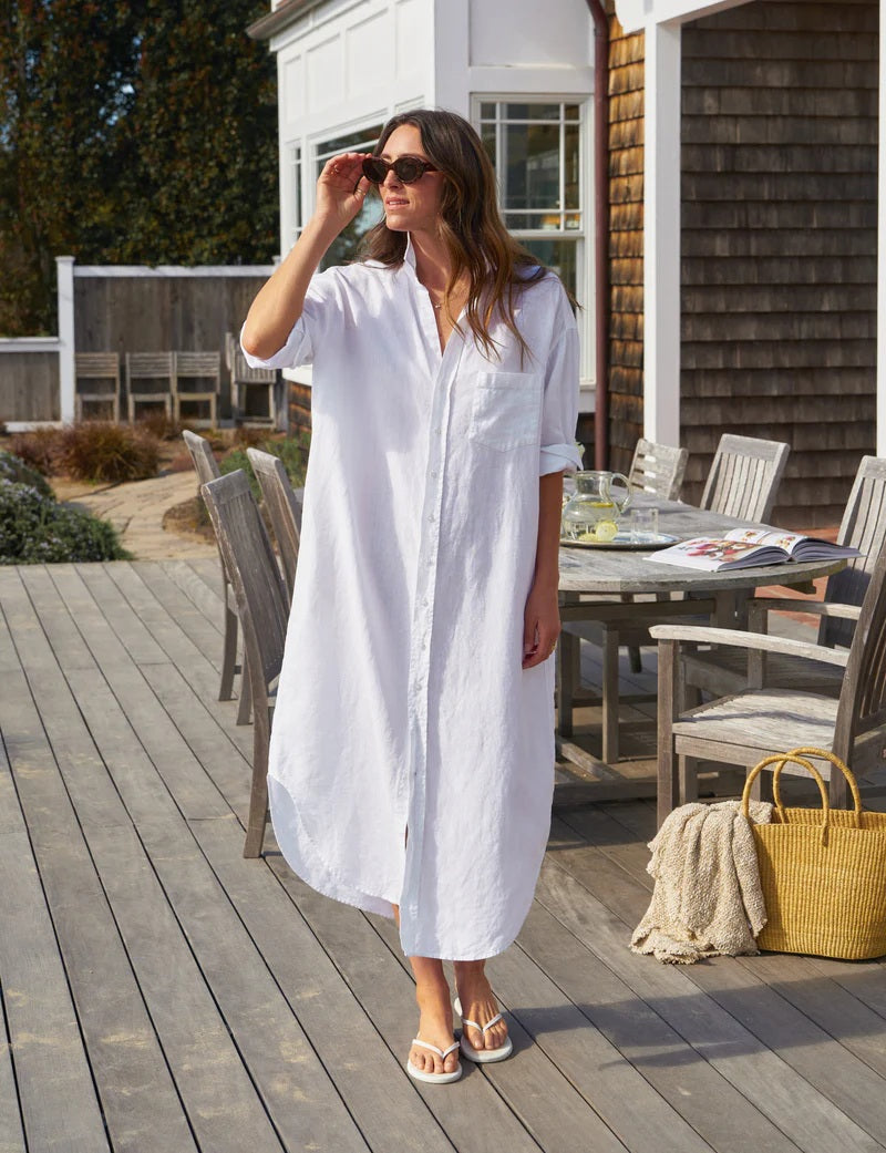 Close-up of a person wearing the FRANK &amp; EILEEN Megan One Size Maxi Shirtdress in washed linen white with a front pocket and rolled-up sleeve. A gold necklace with a small pendant is visible on their neck.