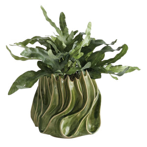 The NAPA HOME AND GARDEN - GREEN CALLISTA VASE, MEDIUM features a sculptural design with glossy green handcrafted ceramic, showcasing wavy, flame-like edges and ridges that evoke the look of abstract leaves or flames. A high-gloss reactive glaze accentuates its flowing, organic exterior shapes, while the interior is finished in a rich dark green.