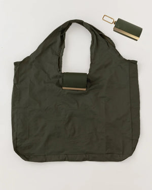 The KEOTE - KEYCHAIN TOTE IN OLIVE by KEOTE is shown flat with a matching foldable case attached to the handle, and a separate rectangular pouch placed at the top right corner.