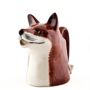 The QUAIL DESIGNS QUAIL CERAMICS - FOX JUG MEDIUM is a handpainted stoneware jug shaped like a fox, with its tail as the handle and its mouth as the spout. It sits on a plain white background and is dishwasher safe.