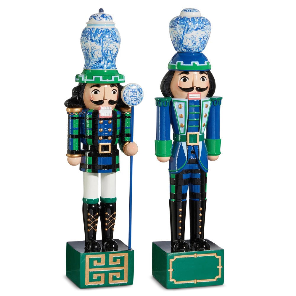 The RAZ IMPORTS BLACK WATCH NUTCRACKER 19&quot; features two decorative figures in ornate blue, green, and black uniforms with porcelain-style hats; one holds a scepter topped with a blue-and-white orb, perfect for home decor.