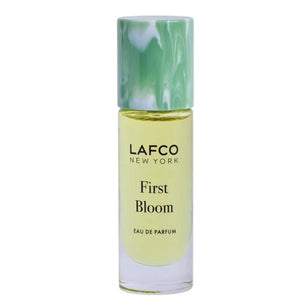 A 10ml bottle of LAFCO Fine Fragrance, First Bloom, a vegan eau de parfum that captures the freshness of spring with luminous neroli and radiant floral notes. Presented by LAFCO, this scent features a marbled green and white cap atop vibrant yellow liquid.