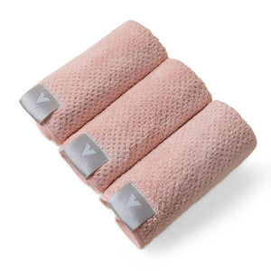 Three VOLO BEAUTY Face Towels from the Pack of 3 are rolled side by side on a white background, each showing a gray tag with the white logo and text, accentuating their luxury Nanoweave fabric.