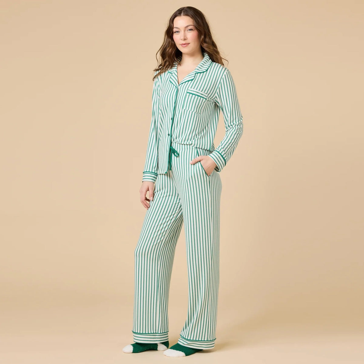 A woman wears the SOFTIES ARIA SLIM NOTCH COLLAR PJ SET, featuring a long-sleeved button-down top and matching wide-leg pants in red and white vertical stripes with red piping details.