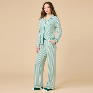 A woman wears the SOFTIES ARIA SLIM NOTCH COLLAR PJ SET, featuring a long-sleeved button-down top and matching wide-leg pants in red and white vertical stripes with red piping details.