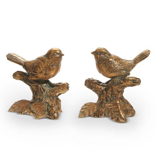 The ANTIQUE GOLD BIRD ON BRANCH sculptures by RAZ IMPORTS feature detailed feather textures and perch on branch-like bases, facing each other. Crafted from resin, these elegant decorative pieces captivate against a plain white backdrop.