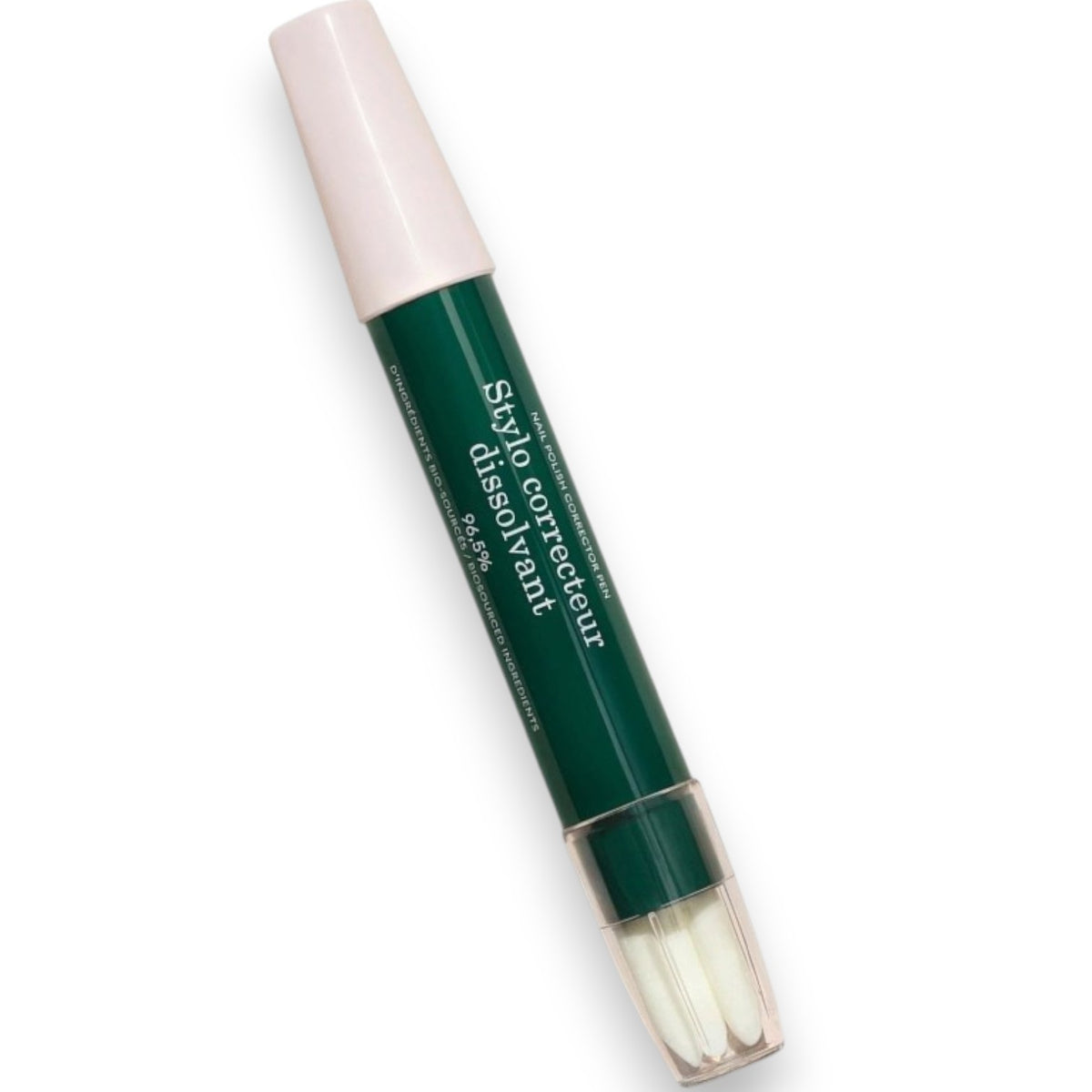 The MANUCURIST - CORRECTOR PEN by MANUCURIST INC lies diagonally on a white background. Reminiscent of a nail polish corrector pen, this green and pink pen labeled “Stylo correcteur dissimulant” features a pink cap and a clear bottom that reveals three white brush tips.