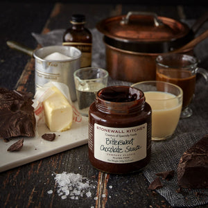A jar of STONEWALL KITCHEN- BITTERSWEET CHOCOLATE SAUCE featuring a dark green lid promises a rich chocolate flavor. The label clearly states that it is gluten-free and weighs 354g (12.5 oz.). This hot fudge sauce is described as a classic from the brand, making it ideal for any dessert indulgence.