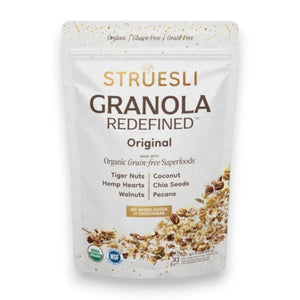 A white bag of STRUESLI - ORIGINAL ORGANIC GRANOLA stands upright, showing tiger nuts, pecans, and walnuts on the packaging. Features include plant-based protein, no sweeteners, grain-free recipe, and prebiotic benefits.