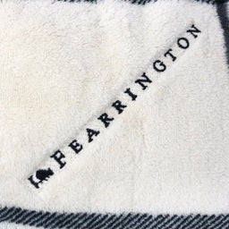 A folded, black-and-white plaid blanket from the FEARRINGTON SIGNATURE COLLECTION by STRAN PROMOTIONAL SOLUTIONS is displayed against a white background. The super-soft throw&#39;s sumptuous feel and classic pattern are prominently visible.