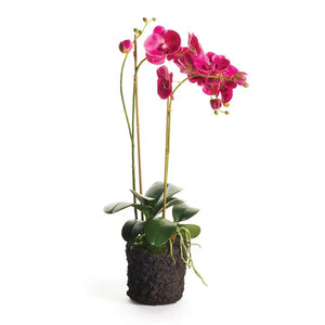 A NAPA HOME AND GARDEN Fuchsia Phalaenopsis Orchid Drop In, 29”, with lifelike blooms in a shiny silver pot, is displayed before a white brick wall; beside it sits an empty silver pot. This artificial plant needs no maintenance.