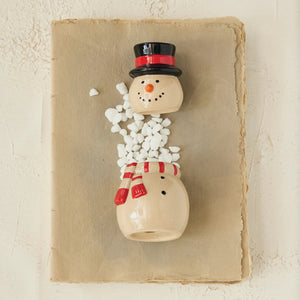 The CREATIVE COOP SNOWMAN JAR WITH LID features a hand-painted snowman with black top hat, red scarf and mittens, black buttons, carrot nose, and brown stick arms on a plain white background.