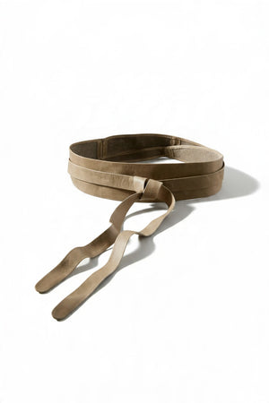 A versatile tan ADA - LEATHER WRAP BELT IN MUSHROOM tied at the waist over a cream-colored button-down shirt.