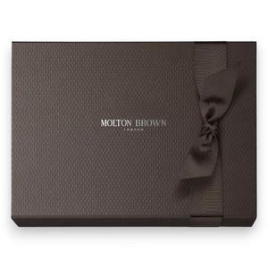 The MOLTON BROWN - BLUEBELL FRAGRANCE LAYERING GIFT SET features a Bluebell & Wild Strawberry body wash, a white lotion bottle with pump, and a slim fragrance spray—elegantly presented on a white textured background.