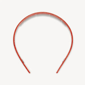 The MACHETE Ultralight Thin Headband in Poppy, crafted from Italian acetate in a vibrant marbled orange and hand-polished for a smooth finish, is shown against a plain white background.