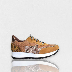 The CORDANI - LIZZIE SNEAKER by CORDANI is a stylish black elastic lace-up sneaker with a white sole, showcasing animal print detail on the heel, a snake pattern on the side, and white laces. Crafted from quilted nylon in Spain, this fashionable shoe is displayed on a light gray background and offers both comfort and flair.
