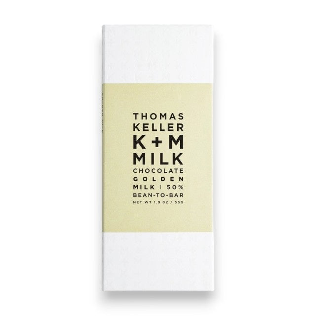 A white wrapper for K &amp; M EXTRAVIRGIN CHOCOLATE's K+M - MILK CHOCOLATE GOLDEN MILK BAR, Net Wt. 1.9 oz/55g, with a light beige central band, black minimalist text, and highlighting Arriba Nacional Cacao.