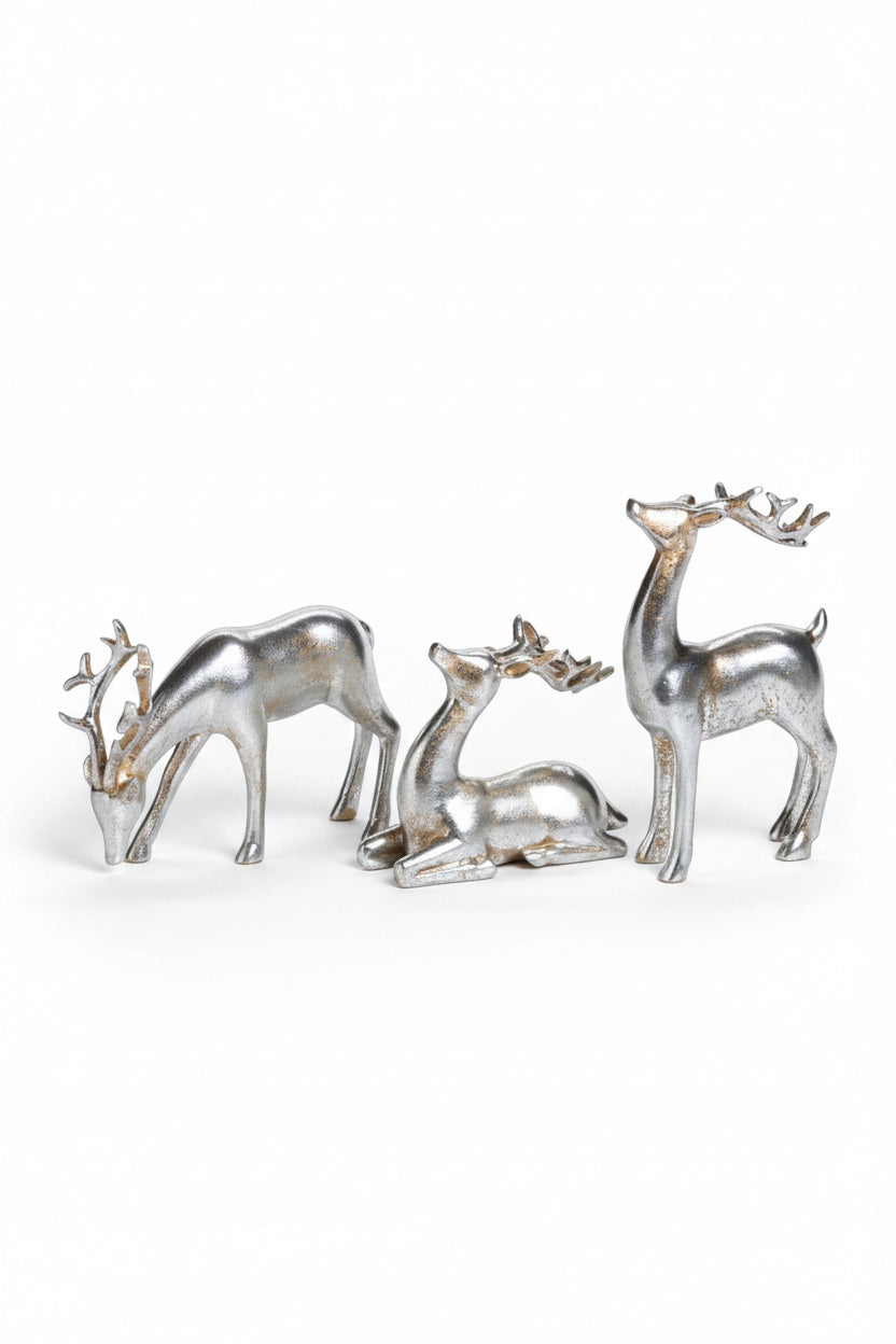 Three silver-colored ZODAX DECORATIVE SILVER REINDEER polyresin figurines in assorted styles on a mirrored tray with two gift boxes wrapped in white ribbon.