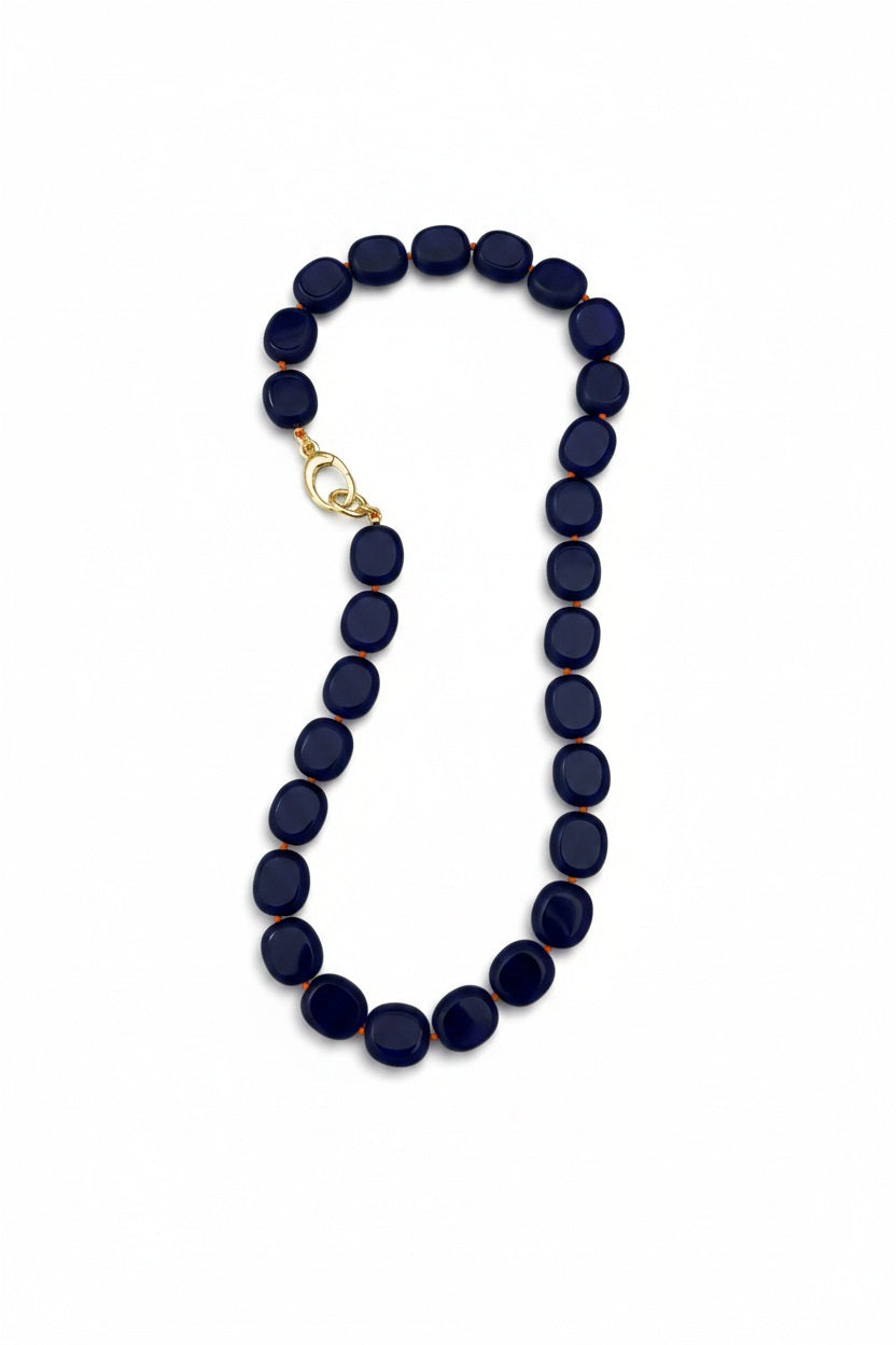 The SANDRINE FRANCE STUDIO - STEFANIE NECKLACE COBALT FUSCHIA is a handmade piece featuring oval-shaped, dark-colored glass beads and a gold-plated clip, showcased against a white background.