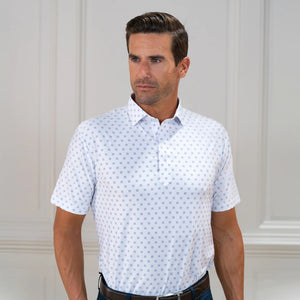 The COLLARS AND CO FEATHERWEIGHT FLEX POLO IN ORACLE WHITE features white fabric with a repeating pattern of small blue 3x3 dot squares. Slightly creased at the center, its 6-way stretch design ensures all-day comfort.