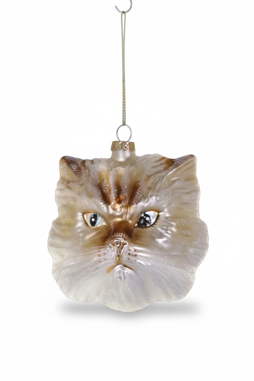 A delicate glass CAT ORNAMENT shaped like a cat’s face in shades of brown and cream.