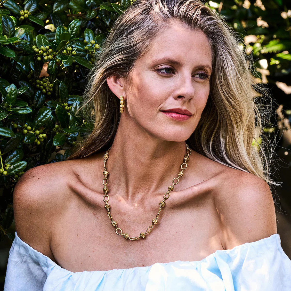 The CAPUCINE DE WULF - BERRY AND BEAD CHAIN NECKLACE 24" is a handmade piece featuring a gold chain with textured ovals and ornate, clustered links, evoking golden berries. Its luxurious and versatile design suits any occasion, beautifully showcased on a plain white background.