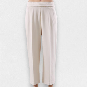 The MEIMEIJ - PONTE PULL ON TROUSER, a pair of beige, high-waisted, straight-leg pull-on trousers from MEIMEIJ, is displayed against a light textured background. These pants feature an elastic waistband, side pockets, and a simple, minimalist design.