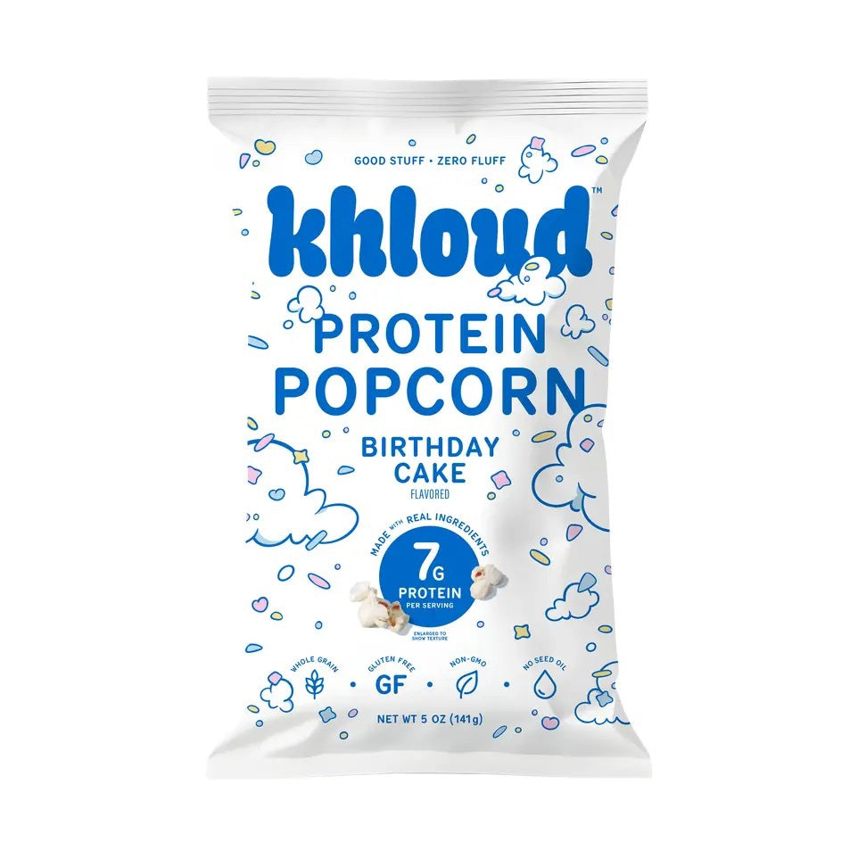 A 5 oz bag of KHLOUD- BIRTHDAY CAKE PROTEIN POPCORN by KHLOUD FOODS features a delicious vanilla cake flavor. The white packaging displays blue clouds, nutritional highlights, and the claim “7g protein per serving,” making this a tasty, protein-powered snack.