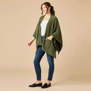 A woman wearing a black SOFTIES - SOLID RIB MARSHMALLOW SHAWL over a grey top and white trousers.