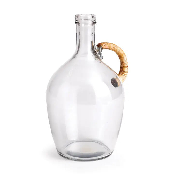 The NAPA HOME AND GARDEN Bohan Glass Jug features a rounded body, narrow neck, and natural cane handle, perfect for a modern farmhouse kitchen. Its simple yet elegant design against a white background embodies curated crafted contemporary style.